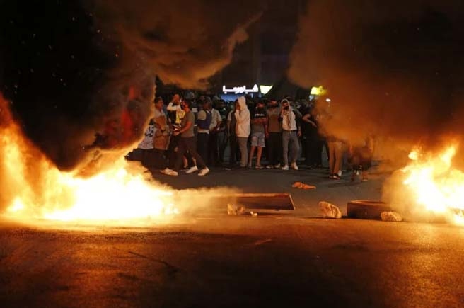 Palestinian protesters burn tires during an anti-Israel demonstration over tension in Jerusalem, near the Jewish settlement of Beit El near Ramallah, in the occupied West Bank, on May 10, 2021.