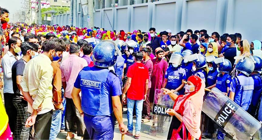 Police stand guard apparel workers during their demonstration on Dhaka-Mymensingh Highway at Kaliakoir upazila of Gazipur district demanding extended Eid holidays on Monday. In the inset: An apparel worker shot and injured after police fired rubber bullet