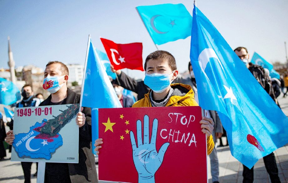 Members of the Muslim Uighur minority hold placards as they demonstrate to ask for news of their relatives and to express their concern, in Istanbul.