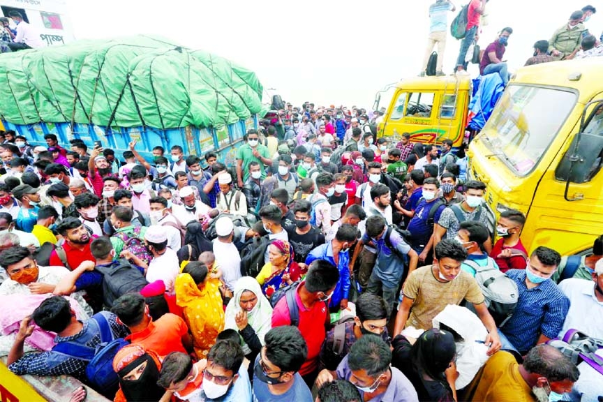 Homebound passengers scramble to get on board a ferry dangerously ahead of Eid holidays at Shimulia Terminal in Munshiganj on Tuesday despite the ongoing pandemic lockdown.
