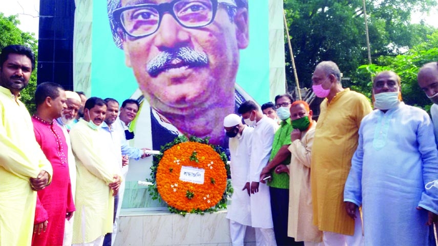 Modhukhali (Faridpur) Upazila Awami League and its associate organizations observe Homecoming Day of Prime Minister Sheikh Hasina placing wreaths at the mural of Bangabandhu Sheikh Mujibur Rahman at the upazila roundabout on Monday.