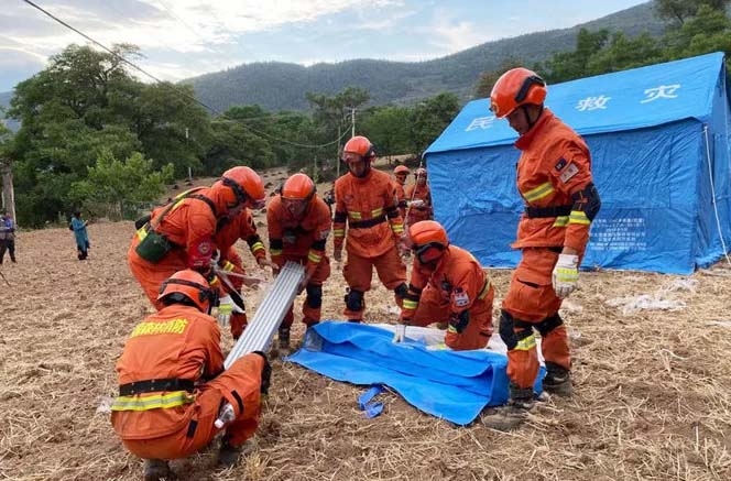 Firefighters set up temporary tents for people displaced by an overnight earthquake in Yangbi County in China's southwest Yunnan province on May 22, 2021.