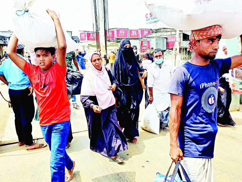 People onrush Dhaka from village homes in order to join their respective work places by a ferry at Paturia ghat on Saturday as long-route transports closed due to lockdown.