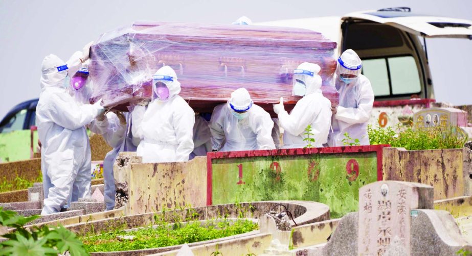 Health workers wearing Personal Protective Equipment (PPE) carry a coffin during a funeral for a COVID-19 victim in Klang, Malaysia, Sunday, May 23, 2021. Malaysia unexpectedly imposed a one-month lockdown through June 7, spooked by a sharp rise in cases,