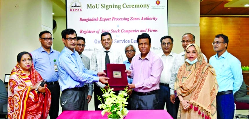 BEPZA member (Investment Promotion) Md Mahmudul Hossain Khan and RJSC registrar Md Mokbul Hossain exchange documents after signing an agreement on behalf of their respective organisations on Sunday at BEPZA Complex in the capital, in presence of BEPZA exe