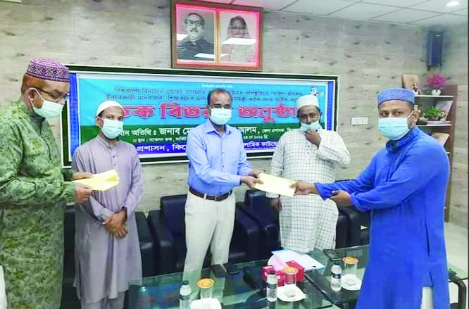 Mohamad Shamim Alam, DC Kishoreganj distributes PM's grants among the Madrasha teachers of the district at a formal ceremony held at the local Circuit house conference room on Monday organized by Islamic Foundation with ADC (General) Md. Golam Mostafa in