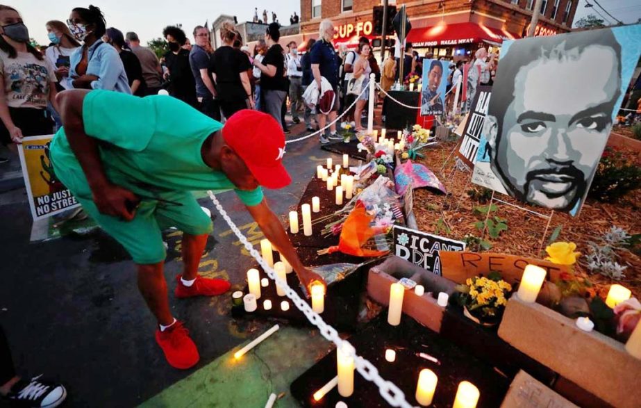 A person places a candle at a memorial during a Celebration of Life festival in honor of George Floyd, who was killed by Minneapolis police one year ago, at George Floyd Square in south Minneapolis, Minnesota, US.