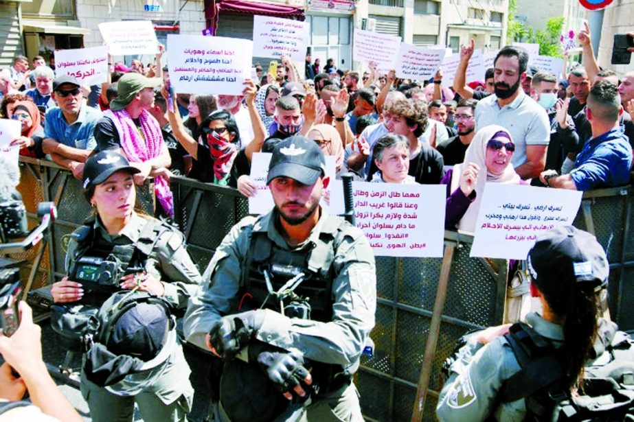 Israeli forces keep watch as Palestinians shout slogans outside the court in Jerusalem on Wednesday during a protest over Israel's planned expulsion of Palestinian families from homes in East Jerusalem's Silwan district.