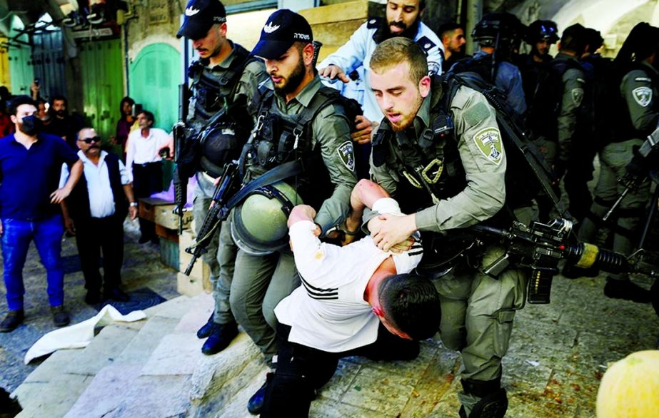 Israeli security force members detain a Palestinian protester during a demonstration held by Palestinians to show their solidarity amid Israel-Gaza fighting, in Jerusalem's Old City.