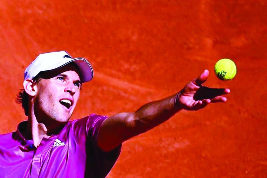 Austria's Dominic Thiem eyes the ball as he serves to Spain's Pablo Andujar during their men's singles first round tennis match on Day 1 of The Roland Garros 2021 French Open tennis tournament in Paris on Sunday.