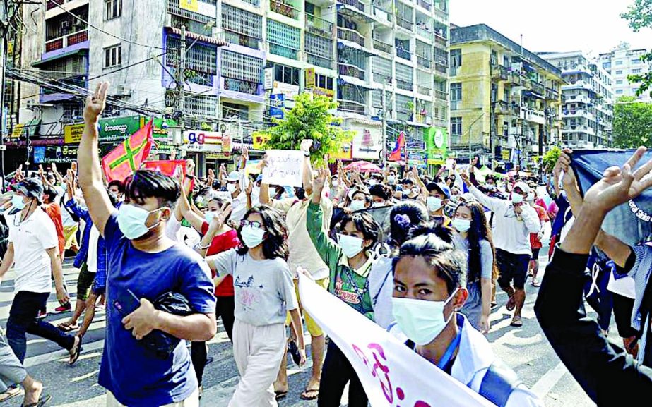 Anti-coup protesters flash the three-finger salute of defiance during a demonstration in Yangon, Myanmar..