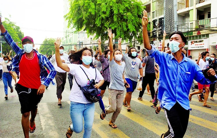 Anti-coup protesters flash the three-finger salute during a flash mob protest in Yangon, Myanmar on Thursday.