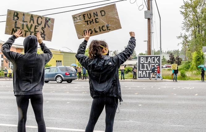 Protesters in an US city show placards demanding defunding of police for their racist activities.