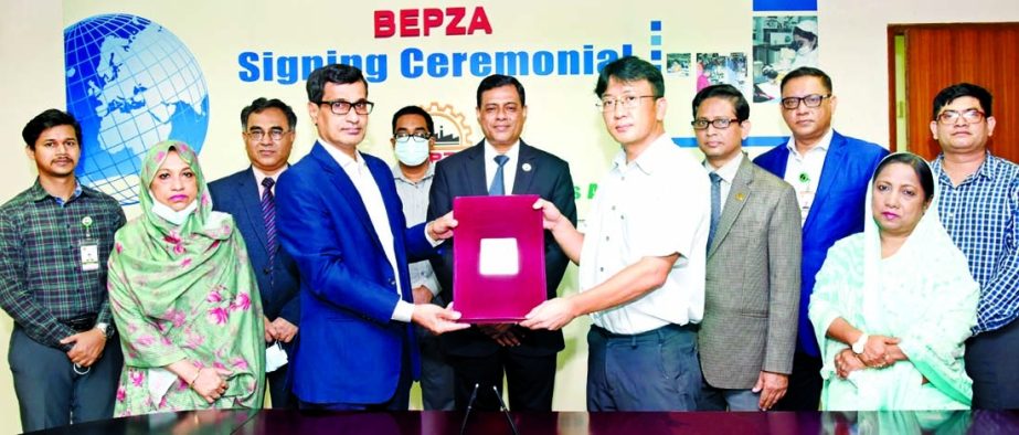 Md. Mahmudul Hossain Khan, Member (Investment Promotion) of Bangladesh Export Processing Zones Authority (BEPZA) and Jin Ho Bae, Chairman of PH Creative (BD), a South Korean company, exchanging document after signing an agreement to establish a camping it