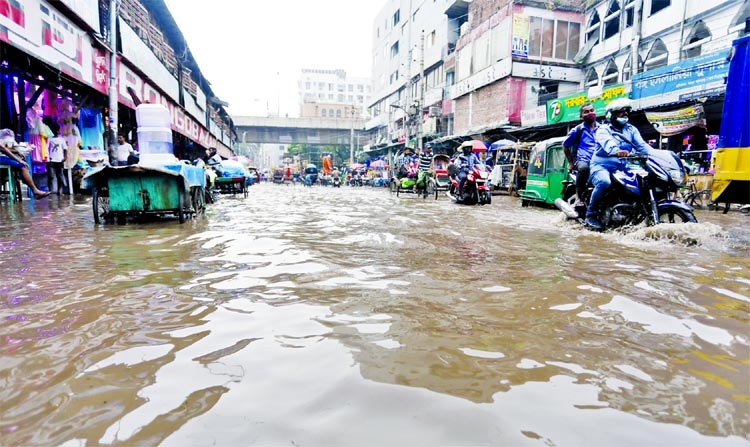 Vehicles ply in a waterlogged road at Bangabazar area in the capital after heavy rainfall on Wednesday.