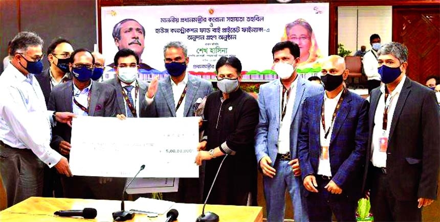 Faruque Hassan, President of the Bangladesh Garment Manufacturers and Exporters Association (BGMEA), handing over donation cheque to Dr Ahmad Kaikaus, Principal Secretary to Prime Minister Sheikh Hasina, at PMO in the capital on Thursday. BGMEA's former