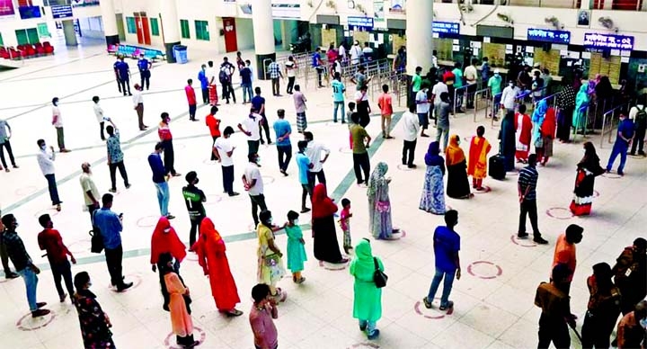 Passengers throng Rajshahi Railway Station ticket counter on Friday by following social distancing norms to get back money against advanced tickets.