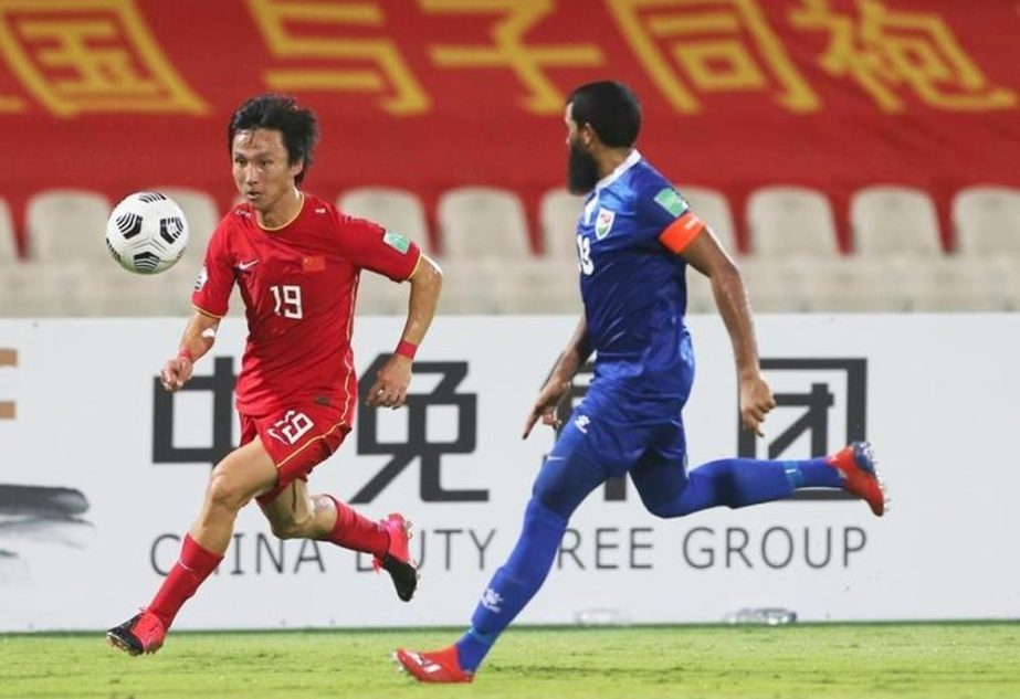 Yin Hongbo of China (left) runs for the ball past Maldives' Akram Abdull Gani during their Group A match of the FIFA World Cup Qatar 2022 and AFC Asian Cup China 2023 Preliminary Joint Qualification in Sharjah, the United Arab Emirates on Friday.