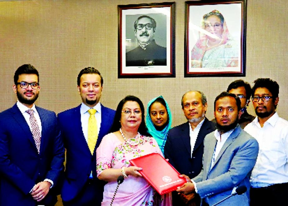 Afroza Khan, Managing Director of Moonno Fabrics Limited and Md. Robiul Islam, Senior Manager of Dhaka Stock Exchange (DSE), exchanging document after signing the re-listing agreement in the capital on Sunday to start transaction of the company's share i