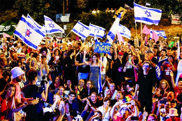 Israeli demonstrators celebrate the new government in the coastal city of Tel Aviv, Israel on Sunday.