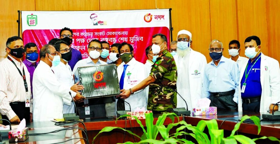 Md. Shafayet Alam, Executive Director of Nagad, a mobile financial wing of the Postal Department, handing over personal protection materials to Professor Dr. Md. Sharfuddin Ahmed, Vice Chancellor of Bangabandhu Sheikh Mujib Medical University (BSMMU) on W