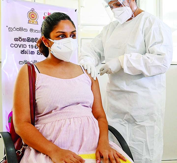 A health worker inoculates a pregnant woman with a dose of the Chinese-made Sinopharm Covid-19 coronavirus vaccine in Colombo.