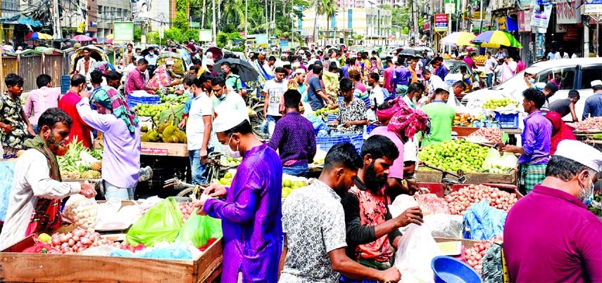 People are seen busy buying essentials and seasonal fruits at a makeshift market set up on an open space in the capital's Nayapaltan area on Friday amid surge in coronavirus infection.
