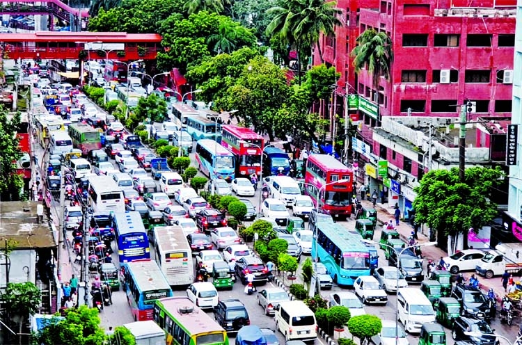 Motor vehicles get clogged at Farmgate area in the capital on Sunday after incessant rains.