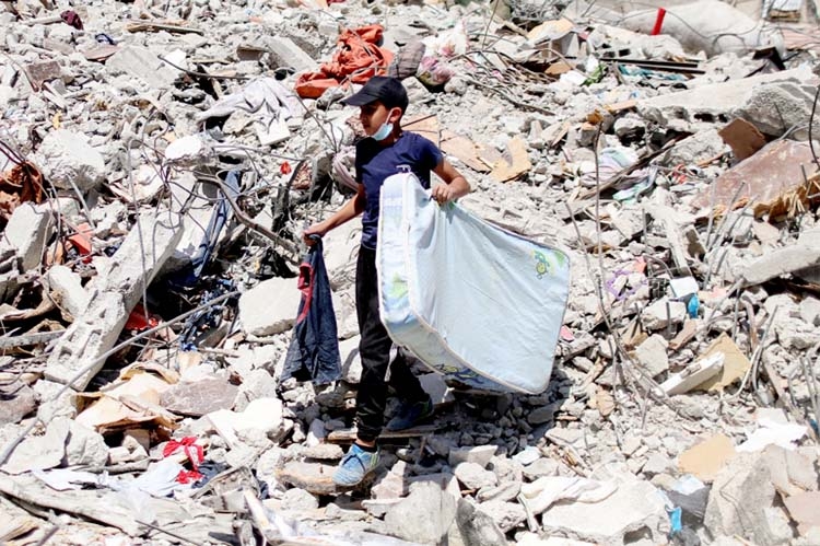 A Palestinian boy walks through the debris of a house destroyed in Israeli air raids on Gaza City.
