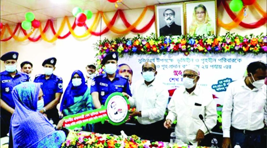 Pabna Deputy Commissioner Kabir Mahmud and Superintendent of Police Mohammad Mahibul Islam Khan, BPM hand over house-keys along with land deeds to the landless families of Pabna as gifts from Prime Minister Sheikh Hasina on the occasion of birth centenary