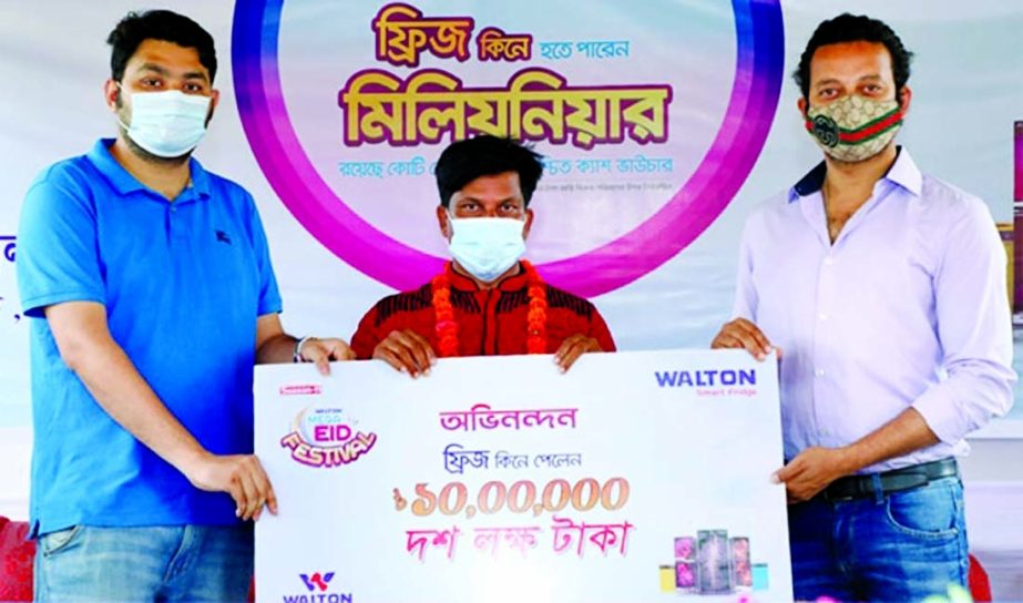Actor Symon Sadik, handing over a cheque of Tk10 lakh to Mazedul Islam at Jaldhaka Walton Plaza in Nilphamari recently. He brought Walton refrigerator under the 'Eid Mega Festival' programme of the nationwide ongoing 'Digital Campaign Season 11'.