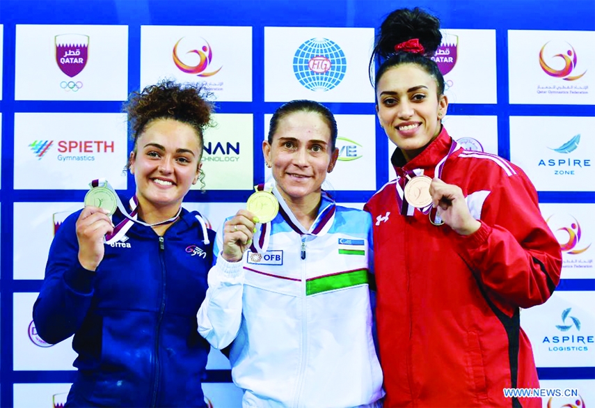 Gold medalist Oksana Chusovitina (center) of Uzbekistan poses with silver medalist Coline Devillard (left) of France and bronze medalist Nancy Taman of Egypt during the awarding ceremony for the Women's Vault Final at the 13th FIG Artistic Gymnastics Wo