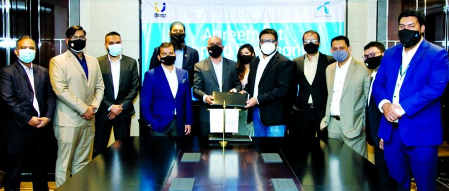 Kazi Mahboob Hassan, Chief Business Officer of Grameenphone and Sydul H Khandaker, Managing Director and CEO of upay, a subsidiary of United Commercial Bank Limited, exchanging documents after signing and agreement at a hotel in the capital recently. Seni