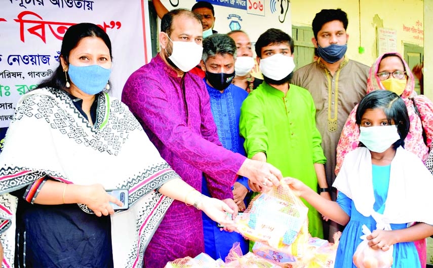 Gabtoli, Bogra Upazila Chairman Rafi Newaz Khan Robin distributes food items among children under humanitarian aid program of Department of Disaster Management at the Upazila Parishad premises on Saturday with Mst. Rawnak Jahan, Upazila Nirbahi Officer in