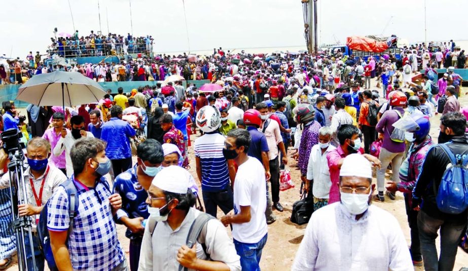 Flouting Covid health safety guidelines, passengers cram into a ferry on their way to village homes at Shimulia River Terminal in Munshiganj on Sunday before the start of a nationwide lockdown.