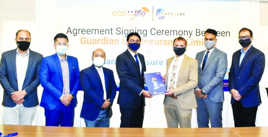 Sheikh Rakibul Karim, Acting CEO of Guardian Life Insurance Limited and Mohiuddin Rasti Morshed, CEO of Carnival Assure, exchanging document after singing an agreement in the capital recently. Top officials from both sides were present.