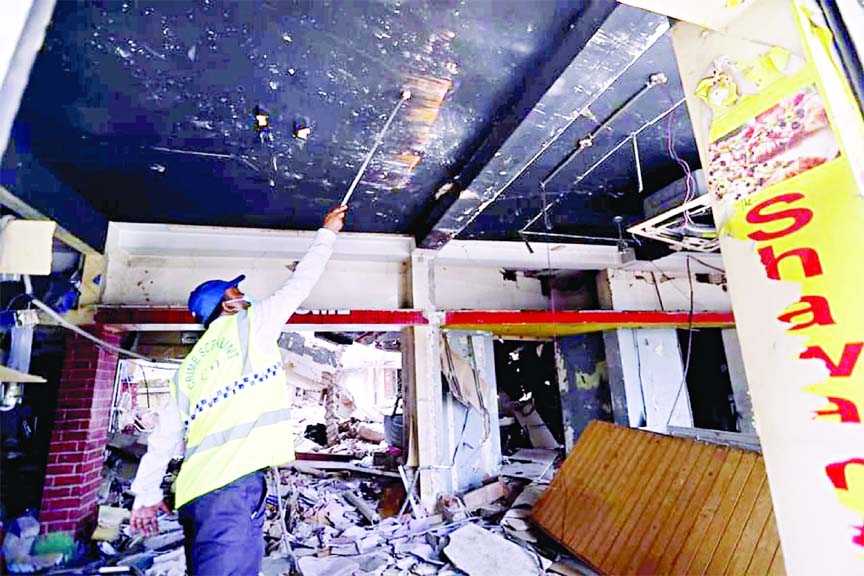 An explosive expert on Monday examines the ceiling of the damaged three-storey building in the capital's Moghbazar where at least seven people were killed and 60 others injured in Sunday's massive blast.