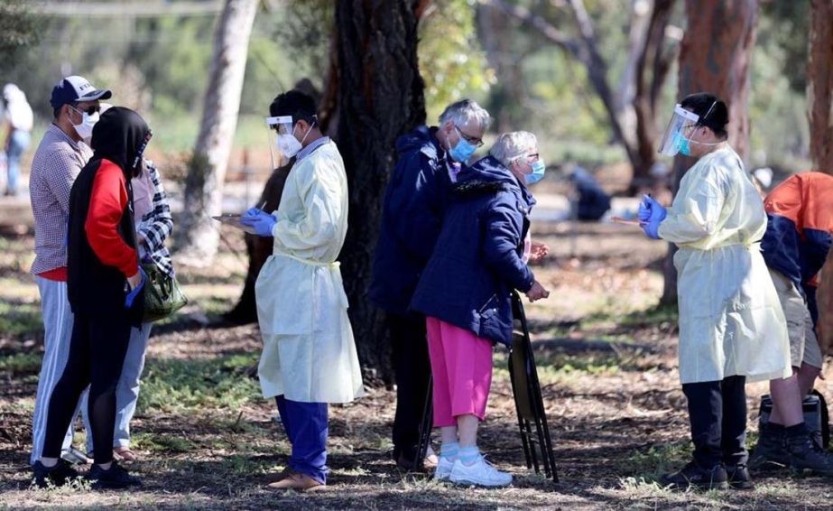Medical staff members take details from people queuing at a Covid-19 testing site as the state of South Australia experiences an outbreak, in Adelaide.