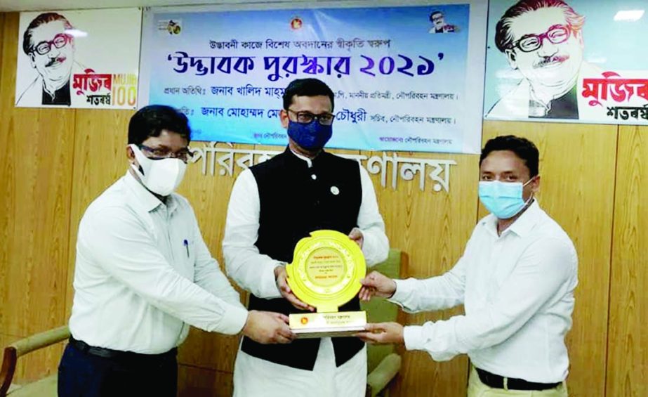 State Minister for Shipping Khalid Mahmud Chowdhury hands over awards to Abdullah Al Mahmud, PS of the Secretary of the ministry Mesbah Uddin Chowdhury for his contribution in innovation work at the seminar room of the ministry on Tuesday.