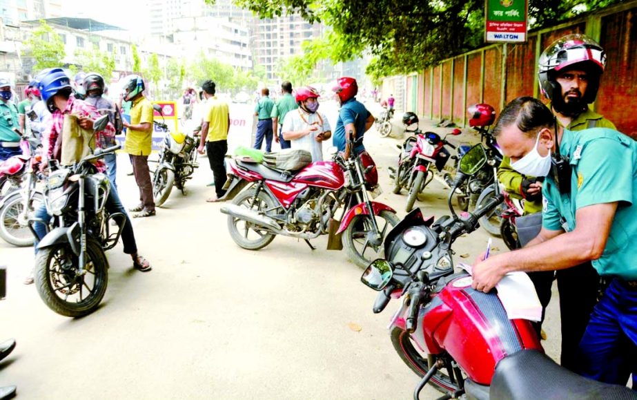 Traffic police stop bikers for ride sharing on the Motijheel- Fakirapool road in the capital on Tuesday.