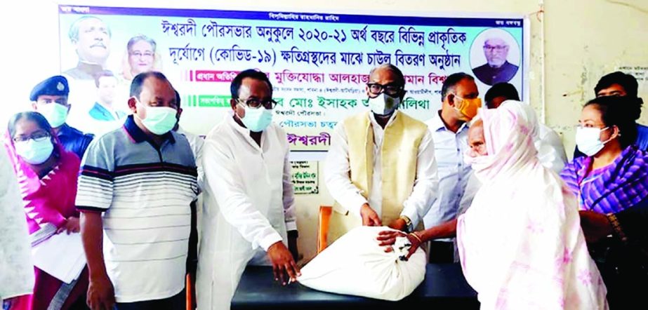 Heroic freedom fighter Nuruzzaman Biswas, MP from Pabna-4 distributes rice among the disaster victim citizens of Ishwardi Municipality at a function held at the municipality premises on Wednesday.