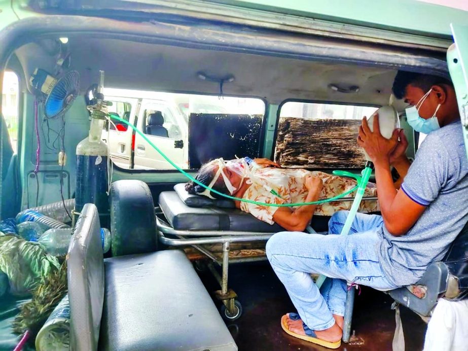 The number of Covid-19 patients is going up day by day in Khulna. This photo taken on Wednesday shows a woman receiving oxygen through pipeline while her son is pumping a rubber balloon to resuscitate her sitting inside an ambulance.