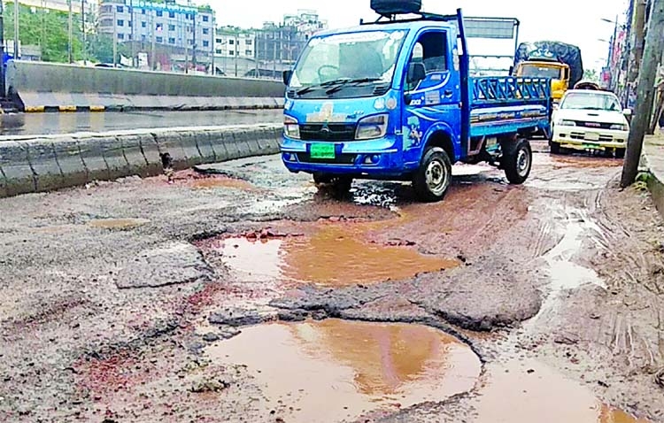 Motorised vehicles seen to struggle through pothole strewn Kutubkhali Road in the city's Jatrabari on Friday. The situation remains the same for long but the authority concerned seemed to be blind to repair the road.