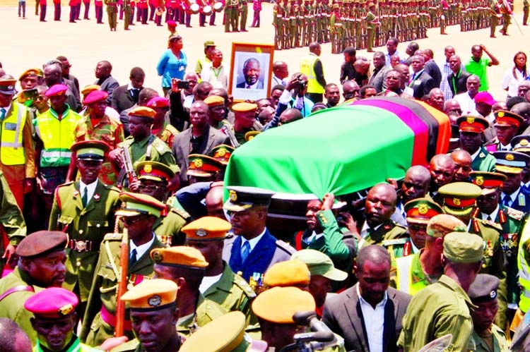 People carry the coffin of Kenneth Kaunda draped in the Zambian flag at National Heroes Stadium in Lusaka, Zambia.