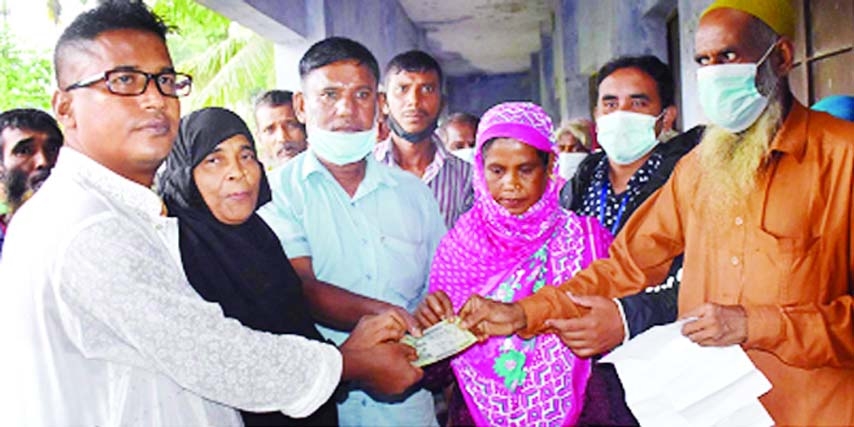 Chairman of the Gabtoli Sadar Union under Bogura district Alamgir Hossain Khan distributes Tk. 500 each given by the Prime Minister Sheikh Hasina among 250 jobless poor people of the Union on Thursday.