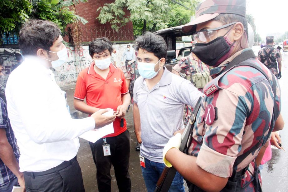 BGB personnel talk to pedestrians as part of conducting a mobile court at Mirpur area in the capital on Sunday to make 7-day strict lockdown successful as well as to keep commoners at home.