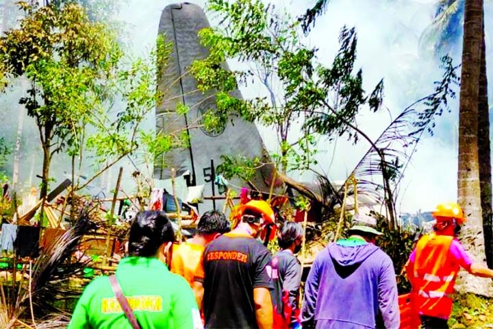 First responders work at the site after a Philippines Air Force Lockheed C-130 plane carrying troops crashed on landing in Patikul, Sulu province, Philippines on Sunday.