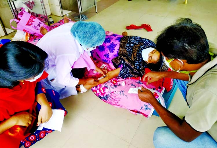 A female Covid patient lying on the floor of Rajshahi Medical College Hospital porch on Sunday as there was not even a single bed empty inside the hospital due to coronavirus surge.