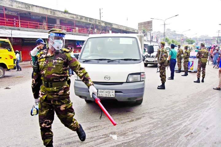An army personnel brings a microbus to a halt at a checkpost at Doyaganj intersection in the capital on the fourth day of strict lockdown on Sunday.