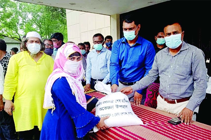 Rangpur Deputy Commissioner Md Asib Ahsan distributes relief items among 500 workers as Prime Minister's gifts to survive in the corona pandemic in a formal ceremony held at the Rangpur District School ground on Sunday.